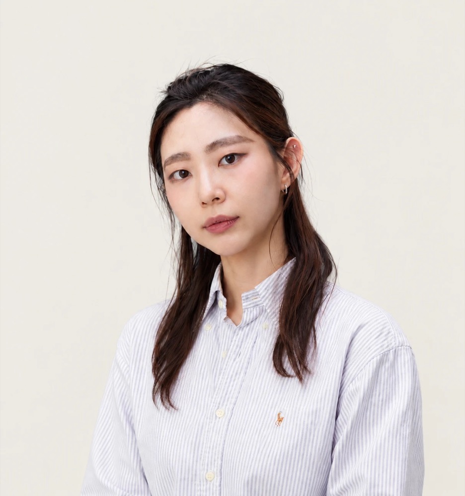 Yedeun Yoon, founder of Nana Kept, in a striped oxford shirt against a warm off-white backdrop.